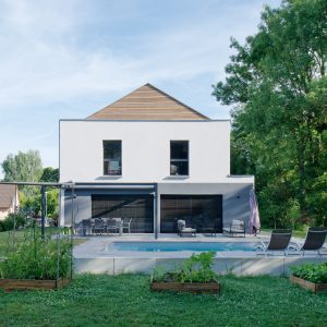 Construction à toiture audacieuse - façade arrière, piscine, jardin et terrasse